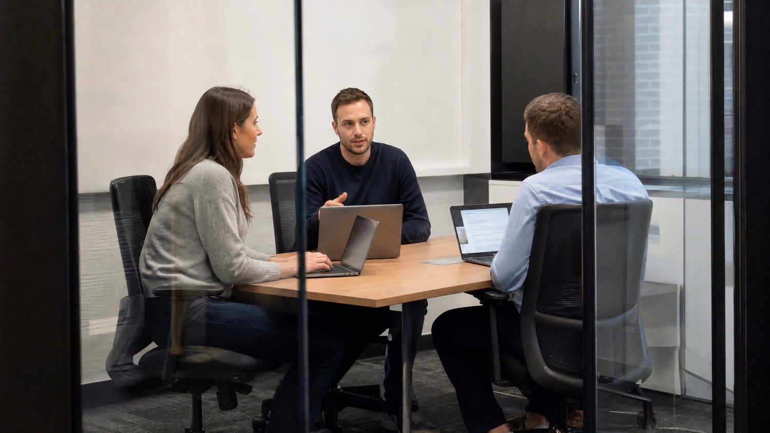 SMALL CONFERENCE ROOM An IT professional three people seated around a small