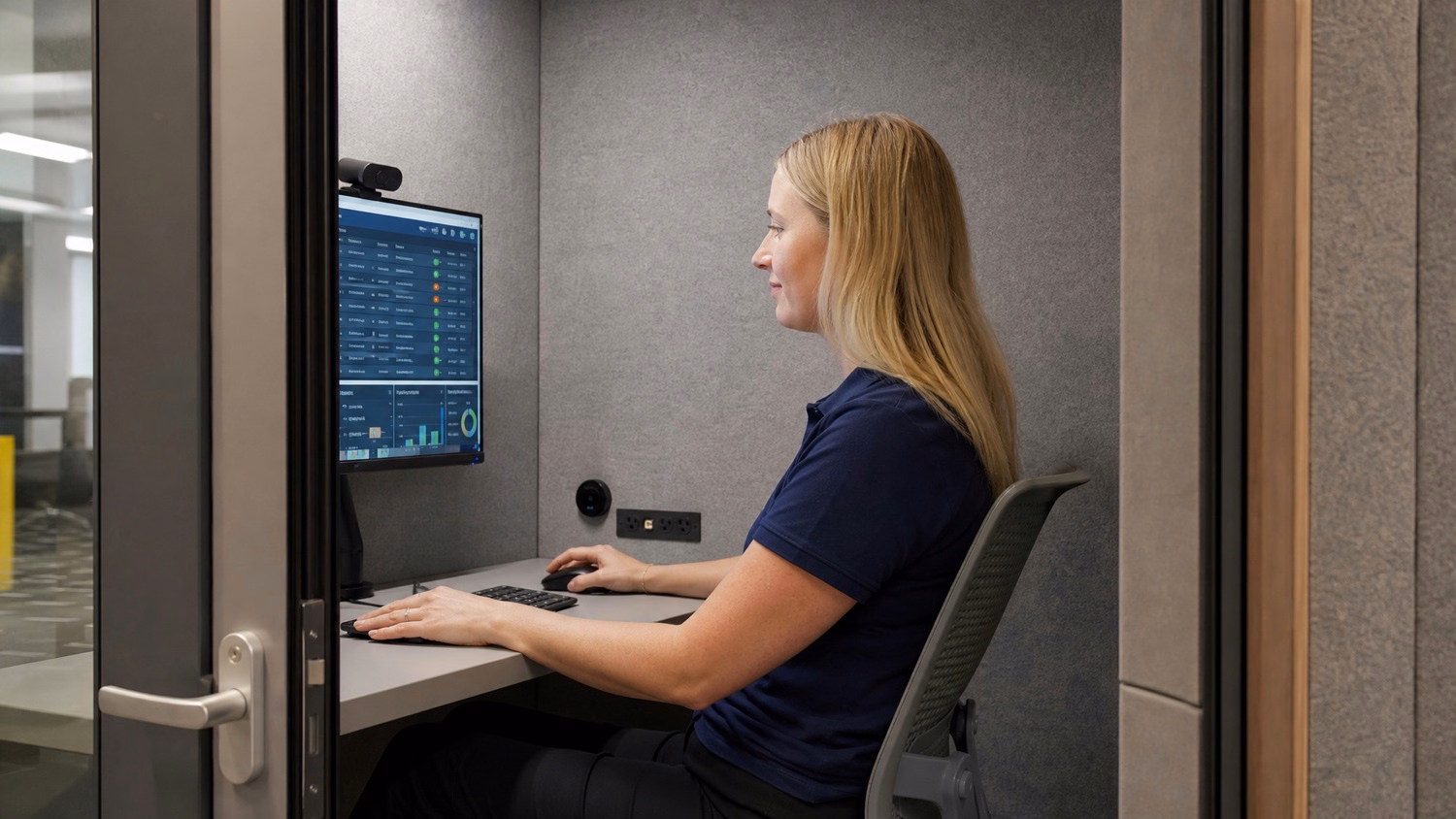 Woman reviews compliance reports in quiet office pod