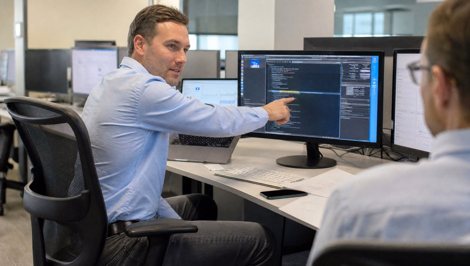Developer pointing at code on computer screen, AI governance