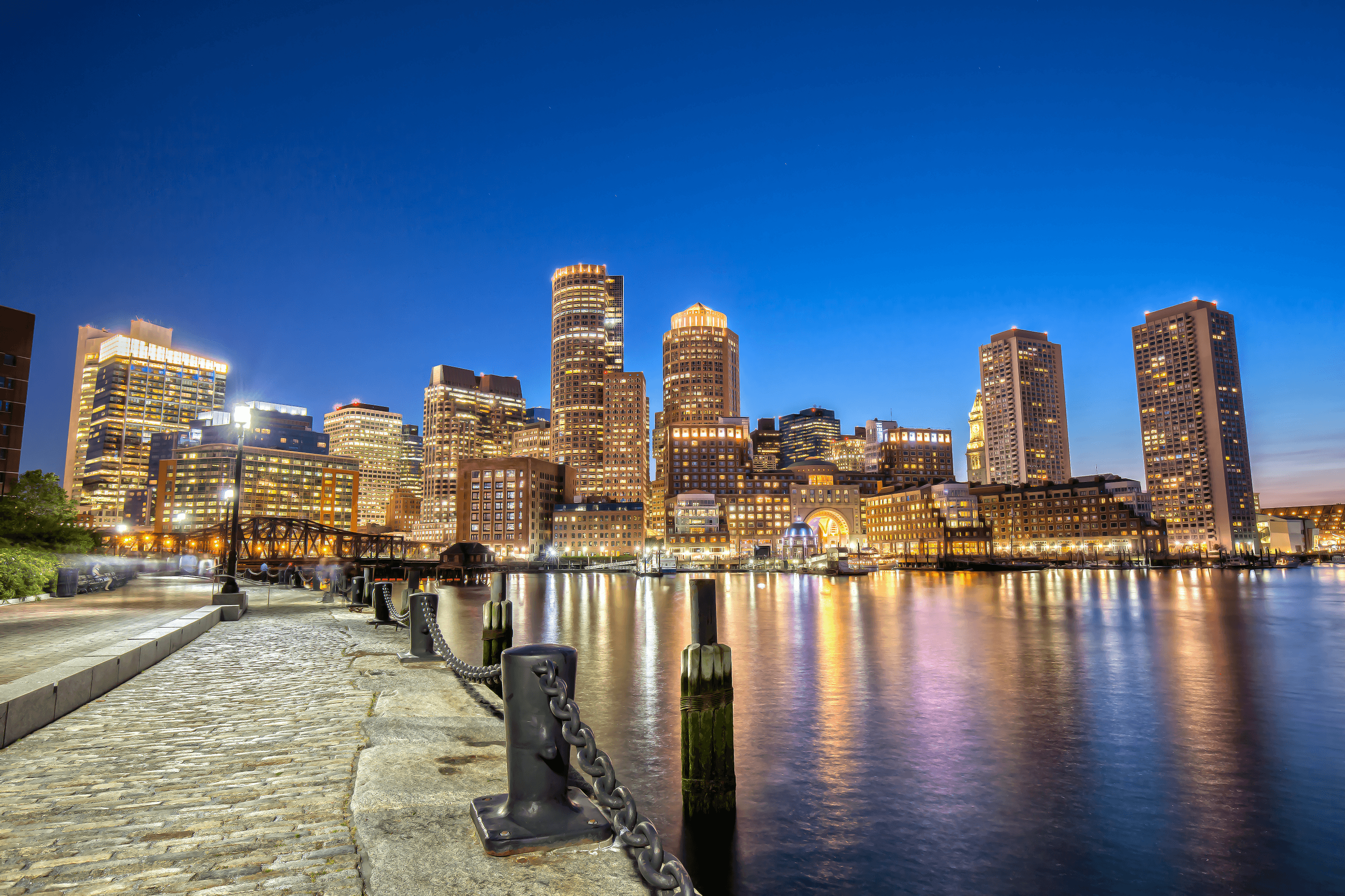 Boston skyline and illuminated waterfront viewed from the Harborwalk at night