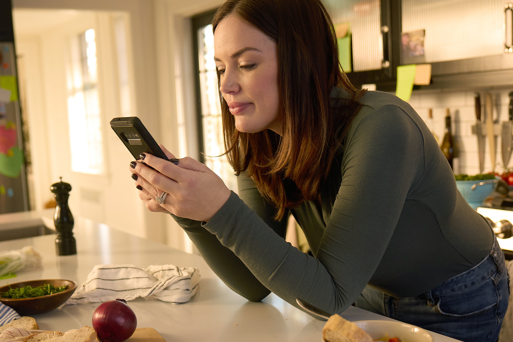 a woman holding and looking at her phone