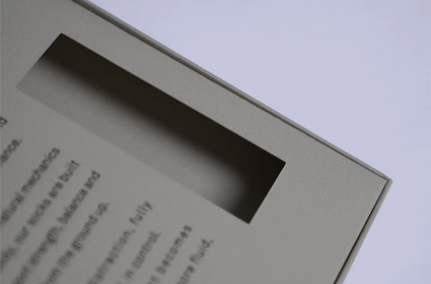 Custom magnetic flip lid box for clothing industry with hook and embossed finish, front view close-up of internal window