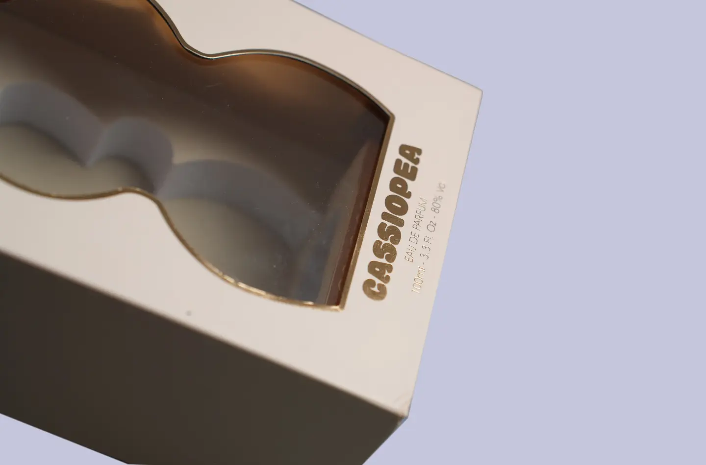 Close-up of bottom gold stamping on a closed perfume book-style packaging box with window