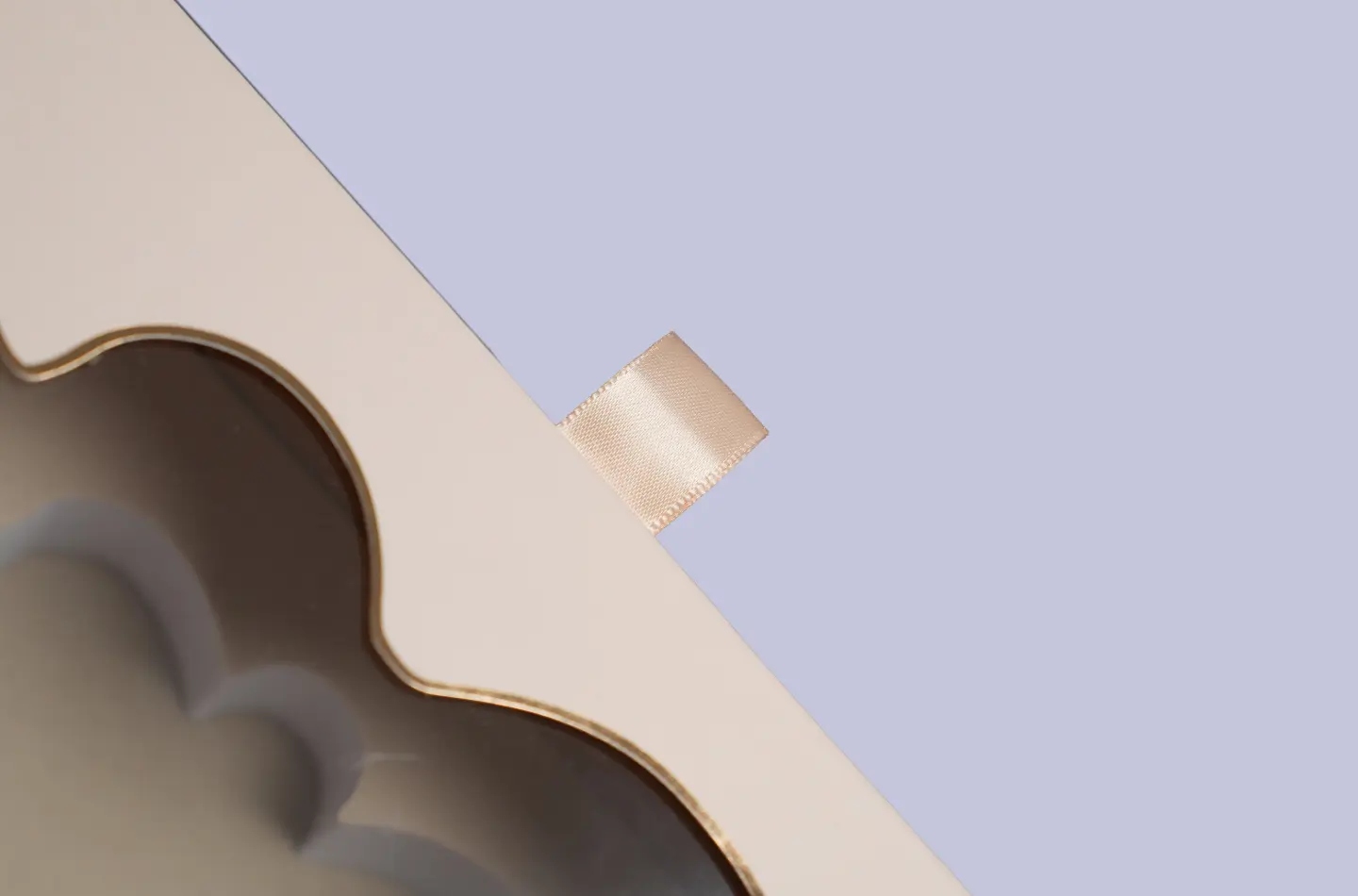 Gold-foil flip-cover detail shown from the side of a windowed book-style perfume packaging box