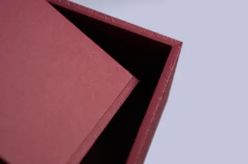 Detail shot showing the rear lid and edge structure of a two-piece embossed tea box opened