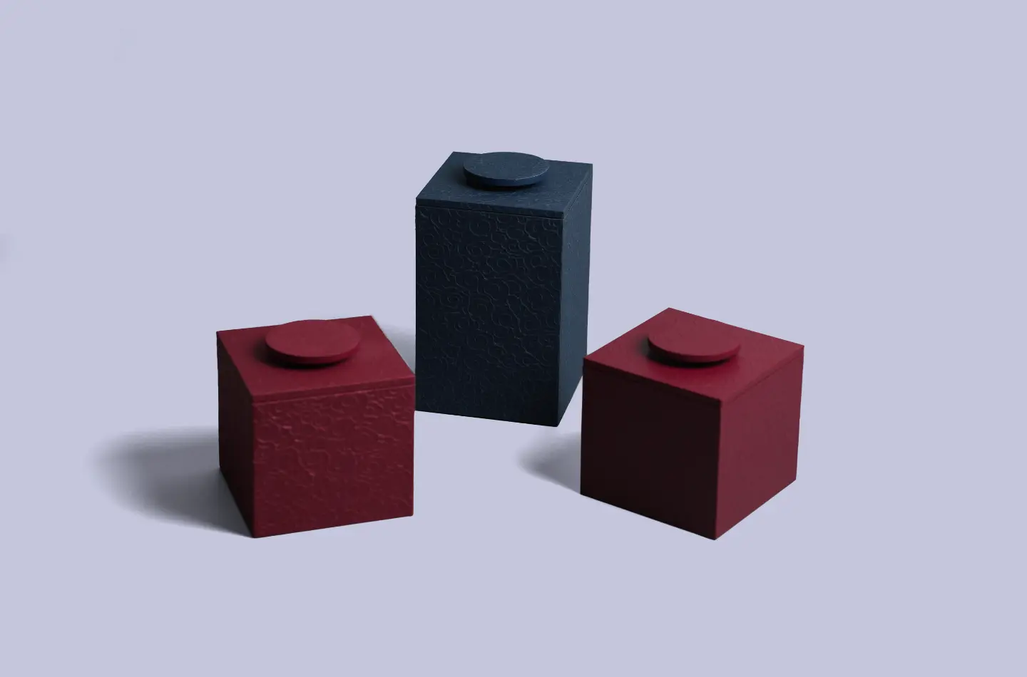 Three styles of two-piece tea boxes with embossed surfaces displayed from the front