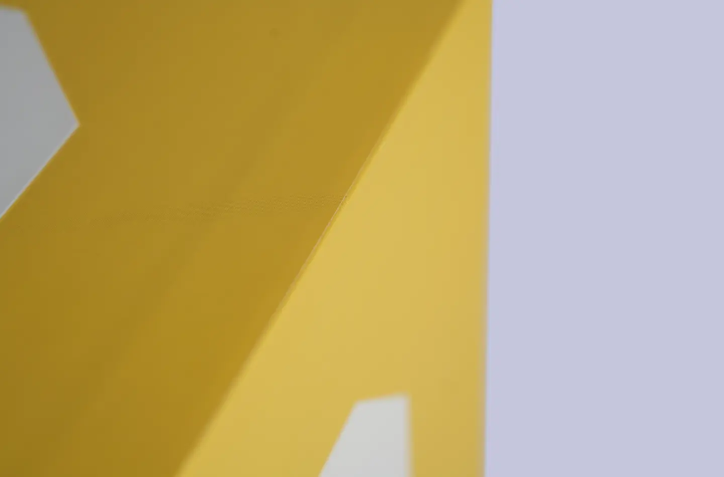 Detail shot showing side edges and corners of a yellow two-piece telescopic box with screen printing