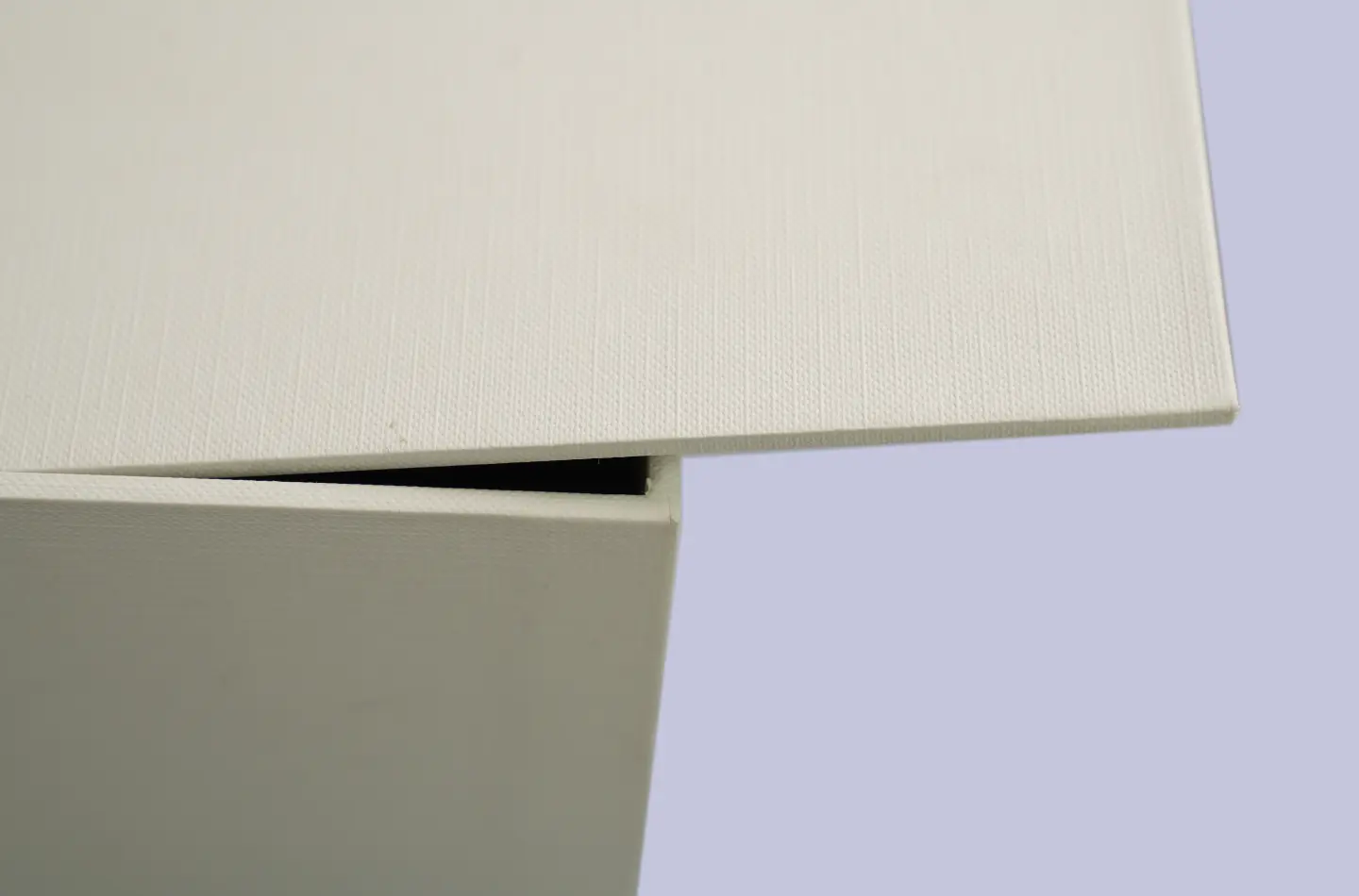 Side view showing the embossed corner and edge details of a double-layer flip-top drawer packaging box with holographic gold accents