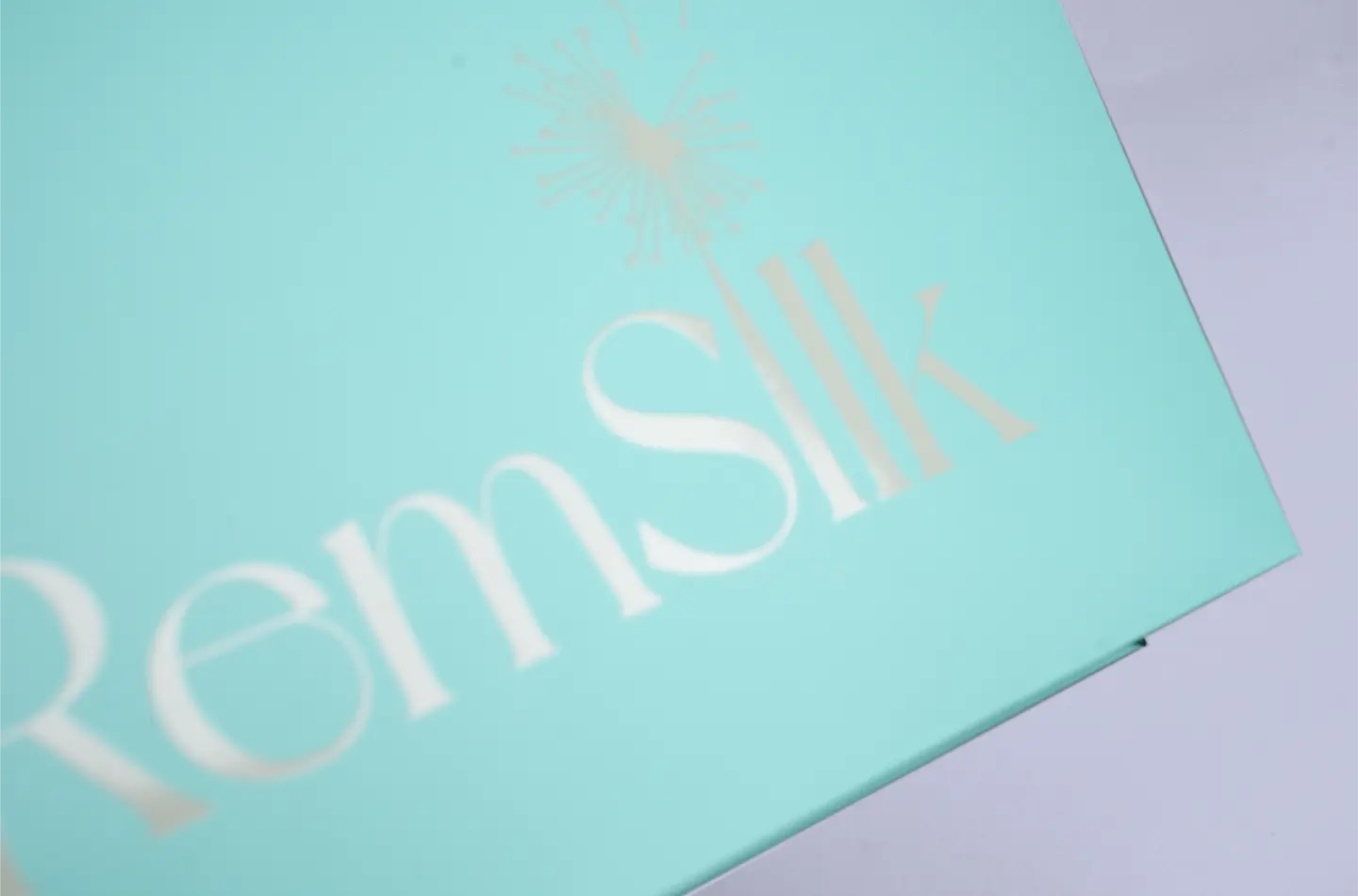 Close-up of screen-printed details on the surface of a Tiffany blue round-arched handbag without waistline