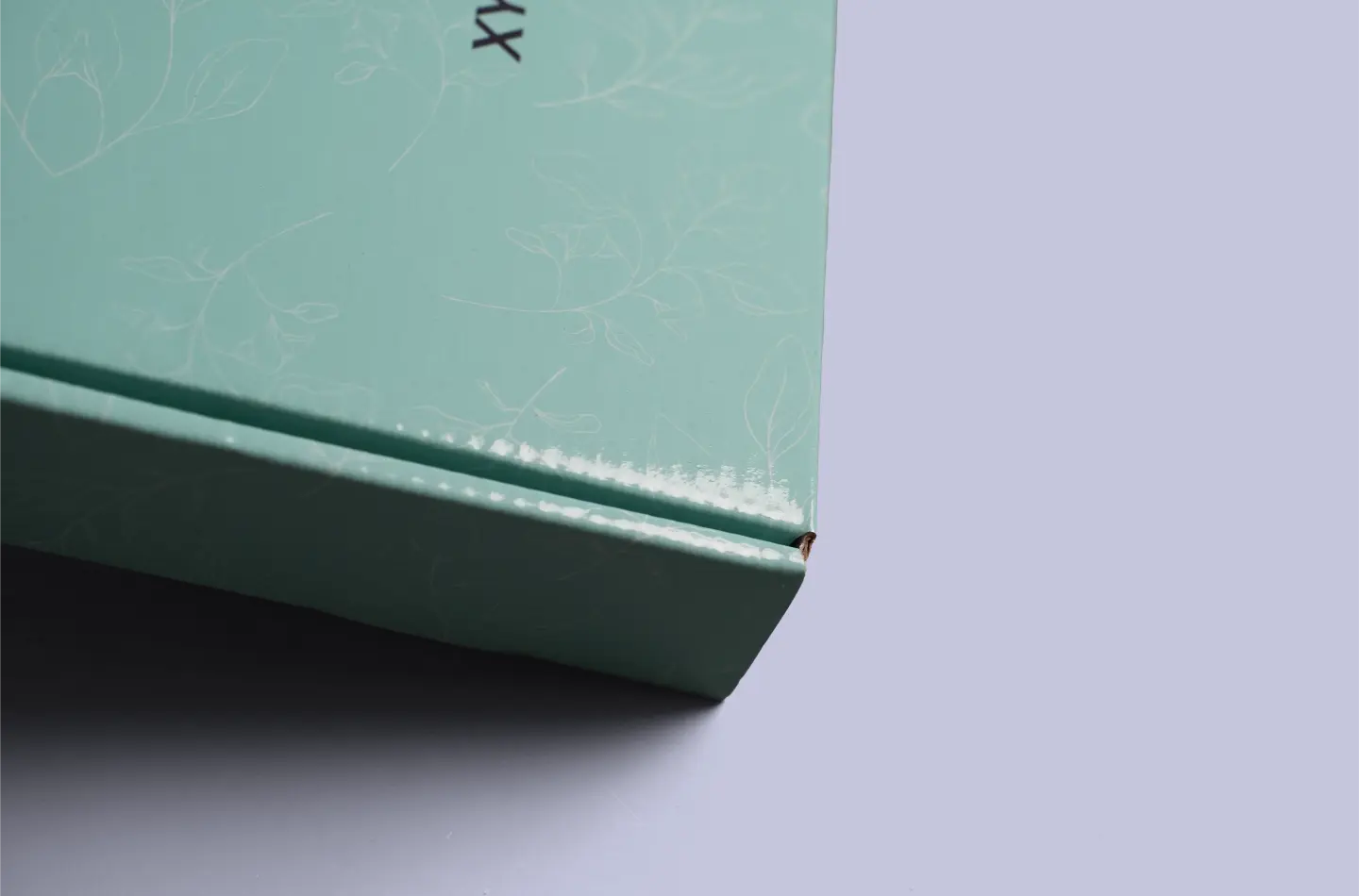 Detailed view highlighting the edges and corners of a ribbon-adorned high-end flip-top tuck box for the food industry