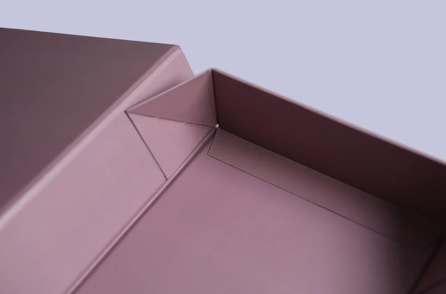 Detail view of the folded corner on a luxury purple magnetic foldable flip-top box, custom design with UV-printed surface