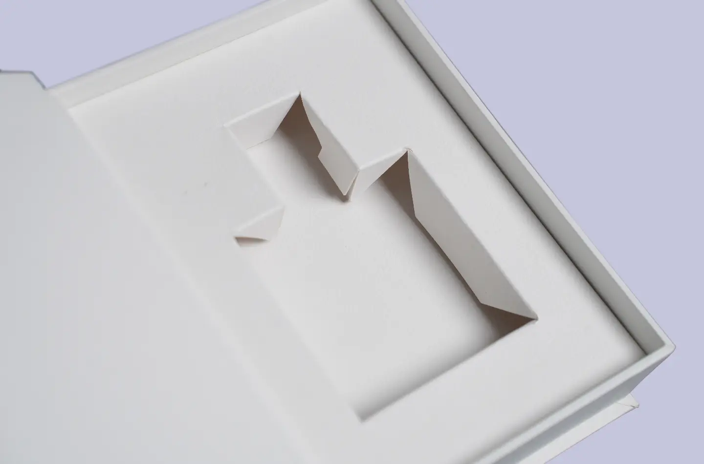 Detail view showing the inner liner inside a white book-shaped box with textured surface