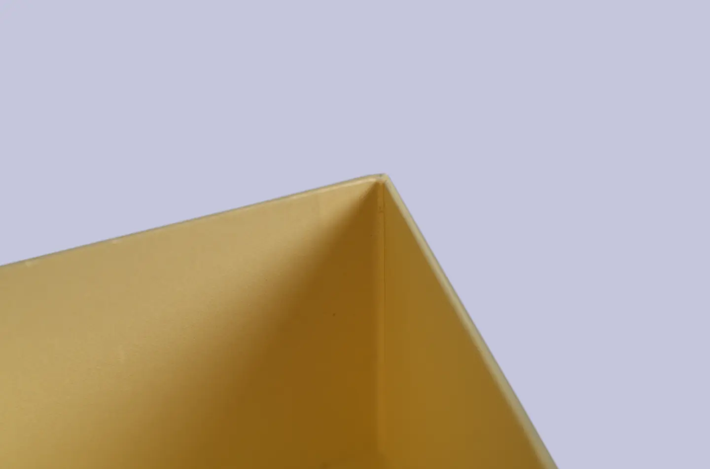 Detailed corner close-up of a gold magnetic flip-top box featuring embossed texture and UV printed finish