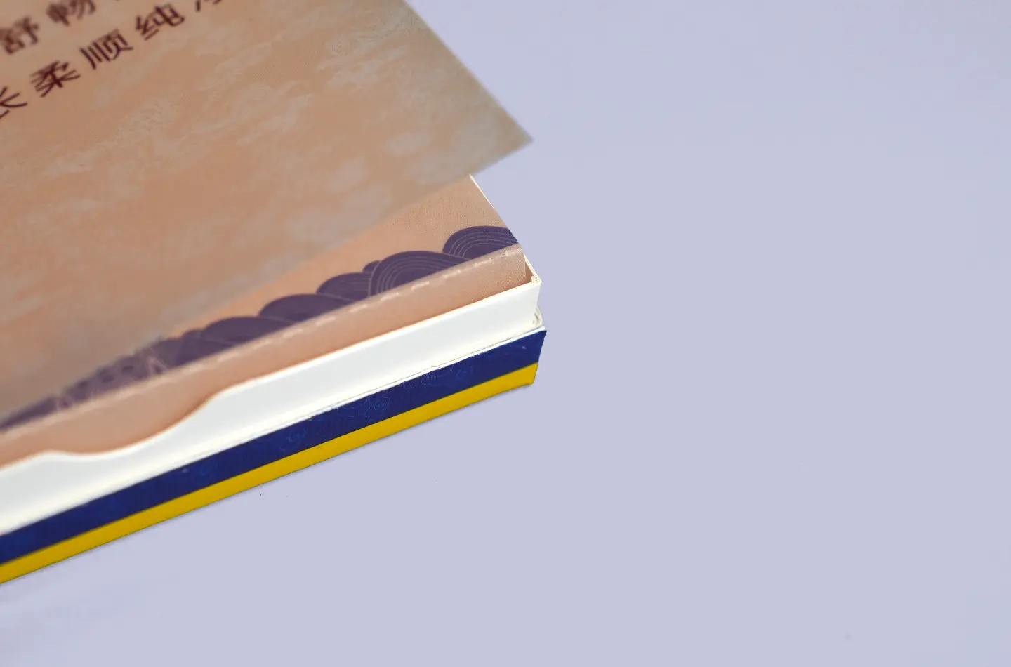 Gold flip-top paperboard box featuring embossed surface and UV printing, detailed view of inner lining and corner edges