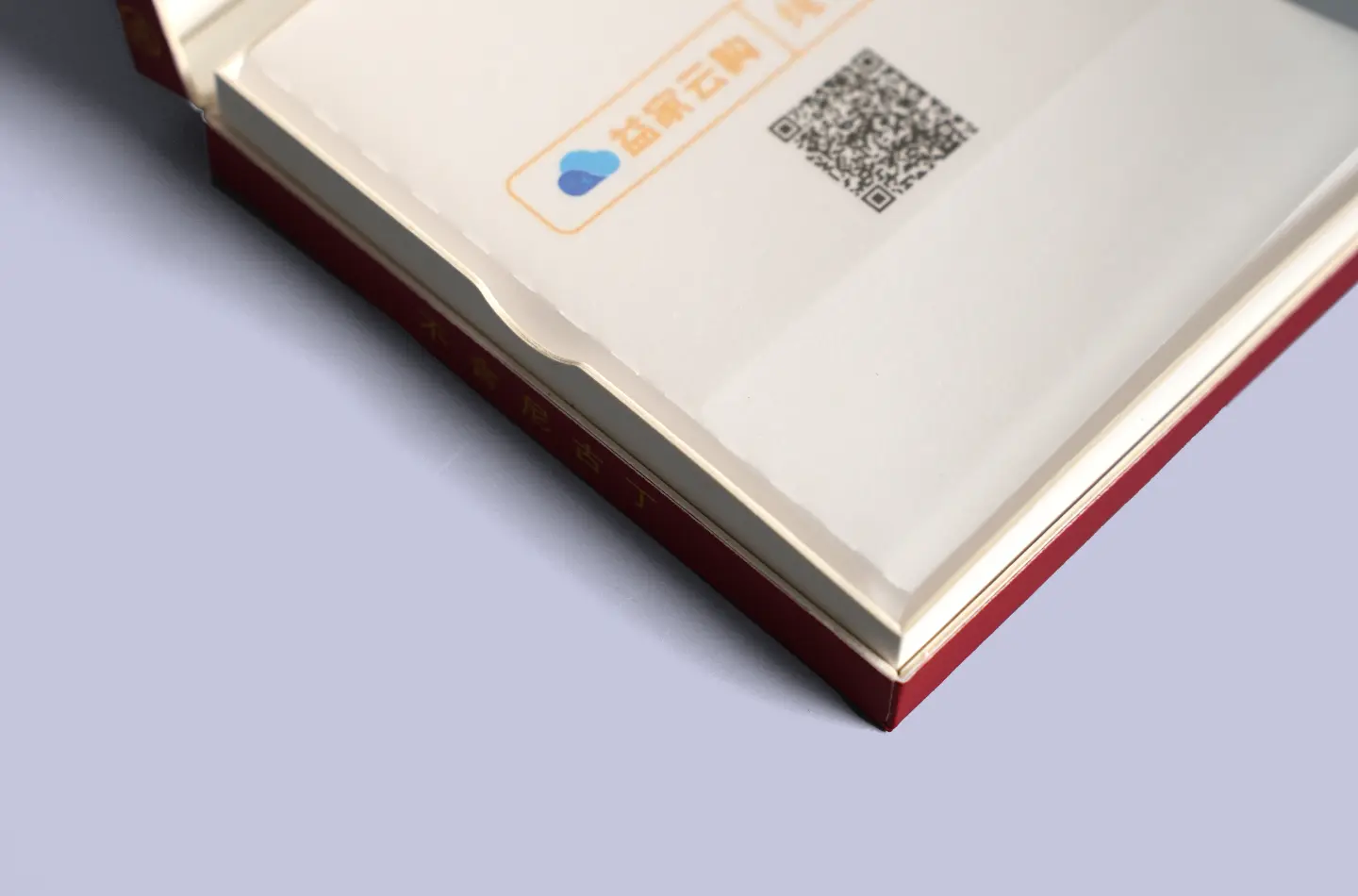 Detailed view showing the textured surface and gold foil finish along the edge of a custom red flip-top paperboard box