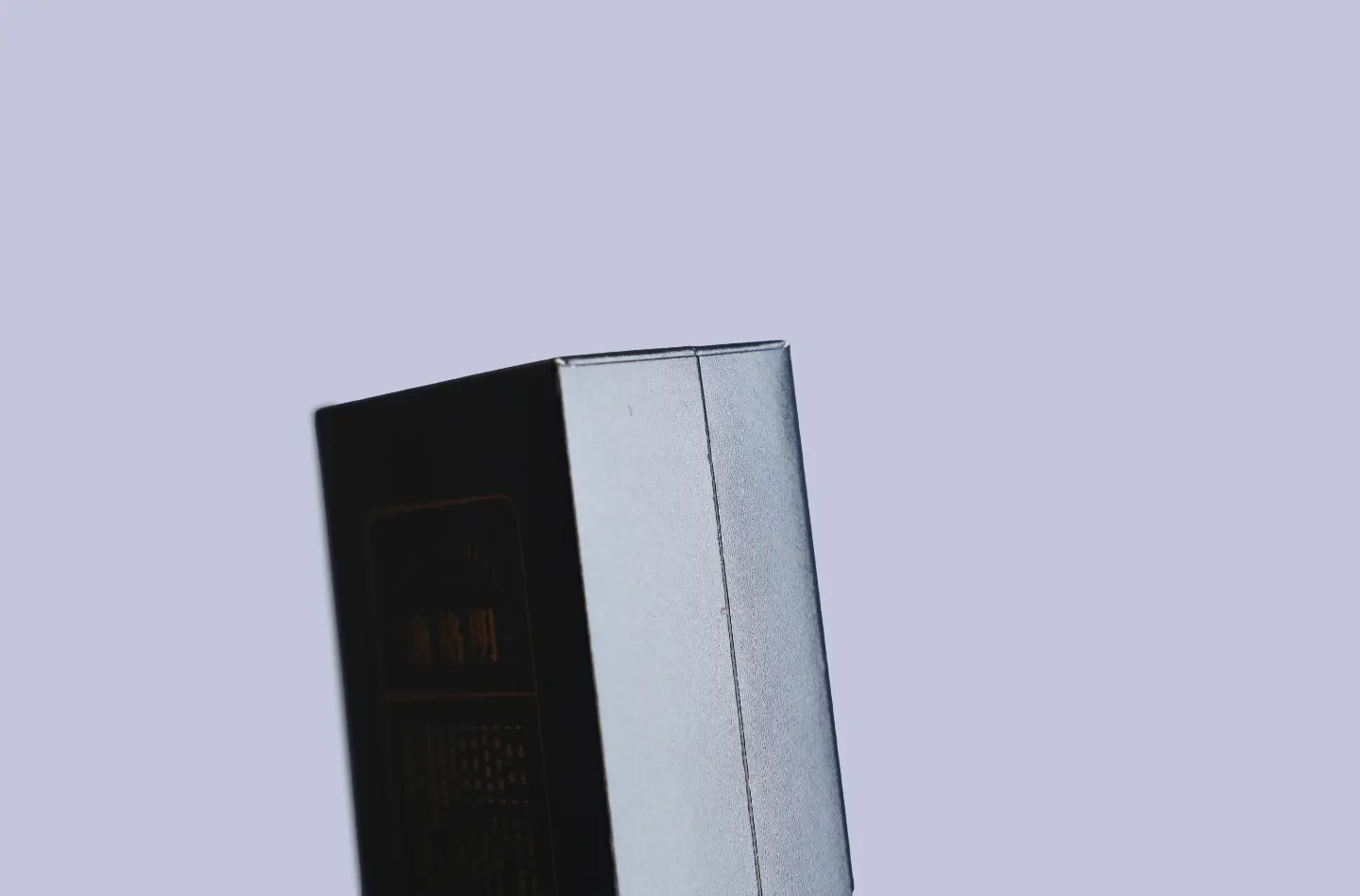 Close-up of the side-opening structure on the olive-green laminated flip-top cardstock box featuring embossed texture