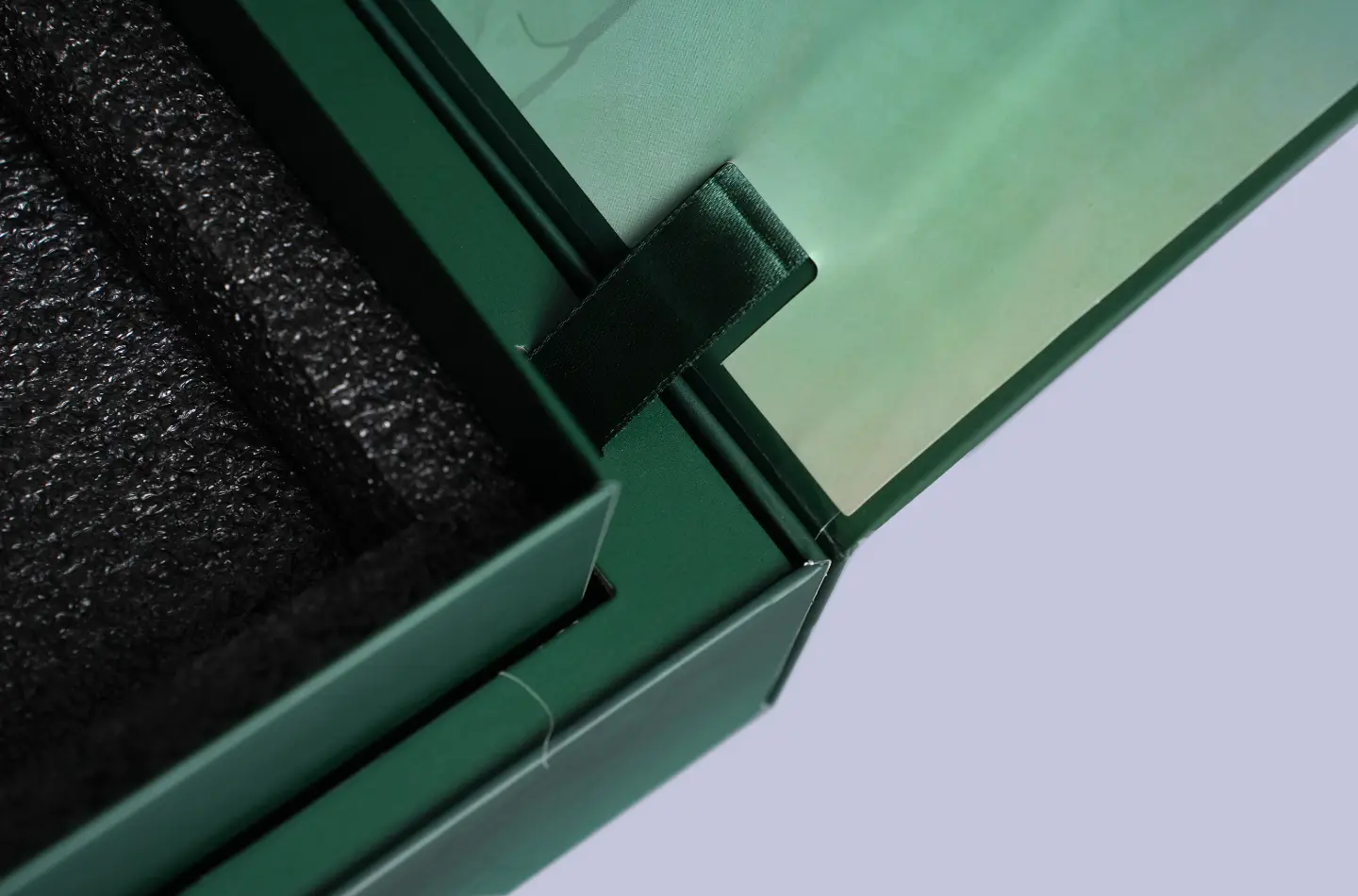 Macro shot showing the lift mechanism on a luxury magnetic lift box with gold foil finishing and interior foam insert