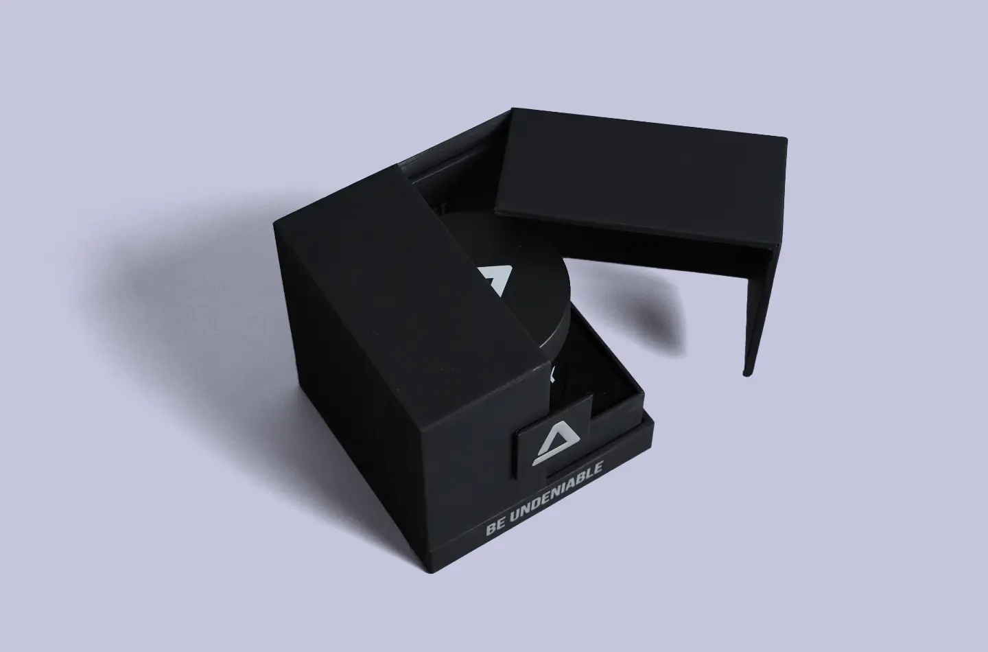 Overhead perspective showing a luxury black magnetic box with silver foil accents partially opened