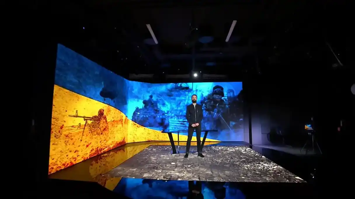 The LED studio opening into a scanned, shelled city street, live on the stream