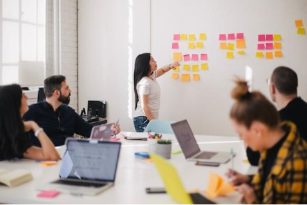 A person pointing at sticky notes on a white boardAI-generated content may be incorrect.