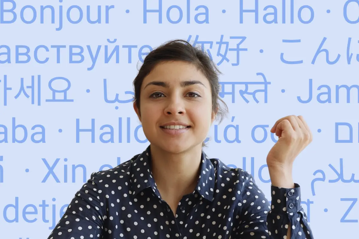 Smiling woman in front of the word “hello” written in many languages