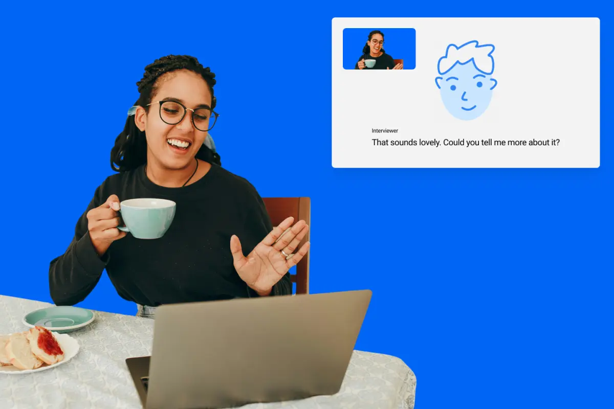 Woman laughing with a cup of tea at her laptop, beside a video call with the Motives AI interviewer