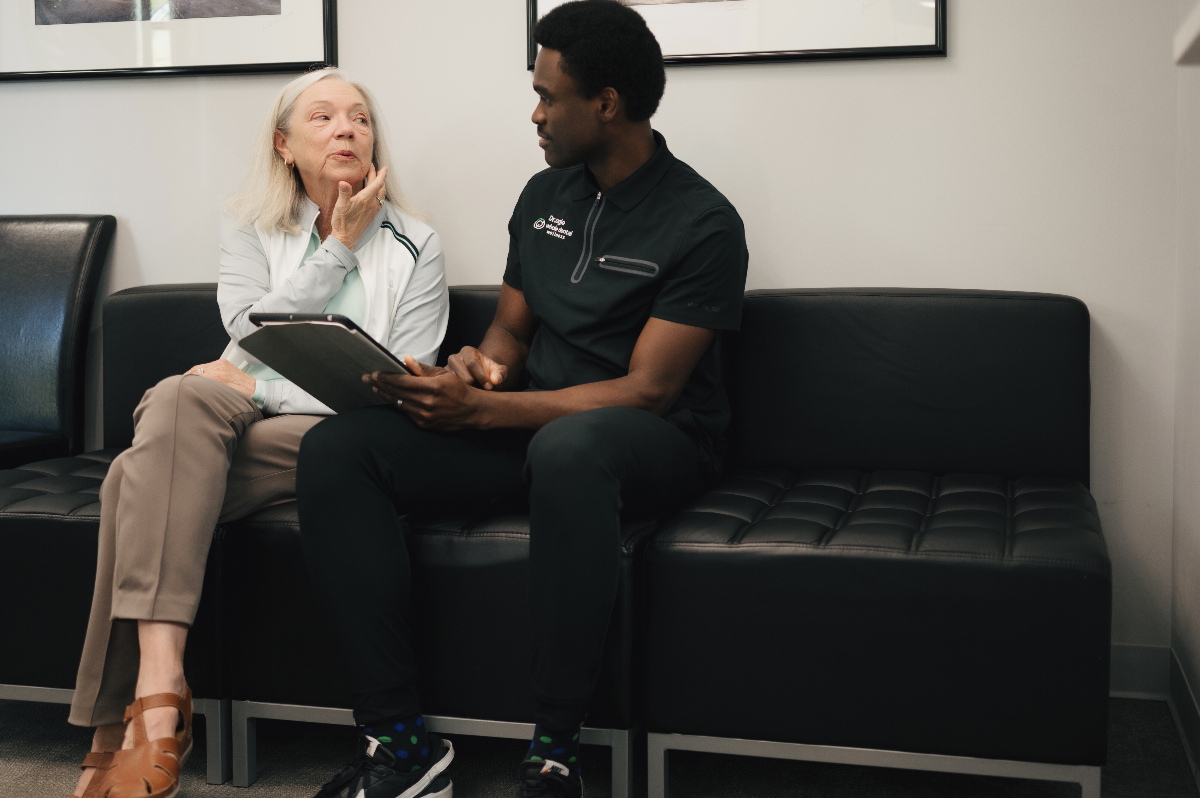Woman sitting on couch with dentist and explaining her dental emergency