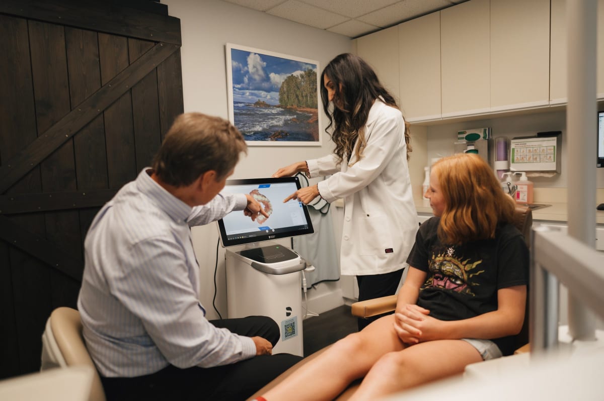 Dental professional performing a clinical examination on a patient in a treatment room