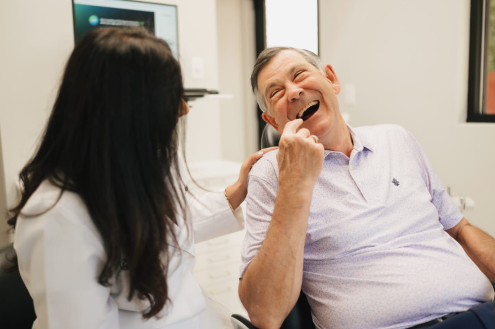 Dental team member in consultation with patients, discussing treatment in a clinical setting
