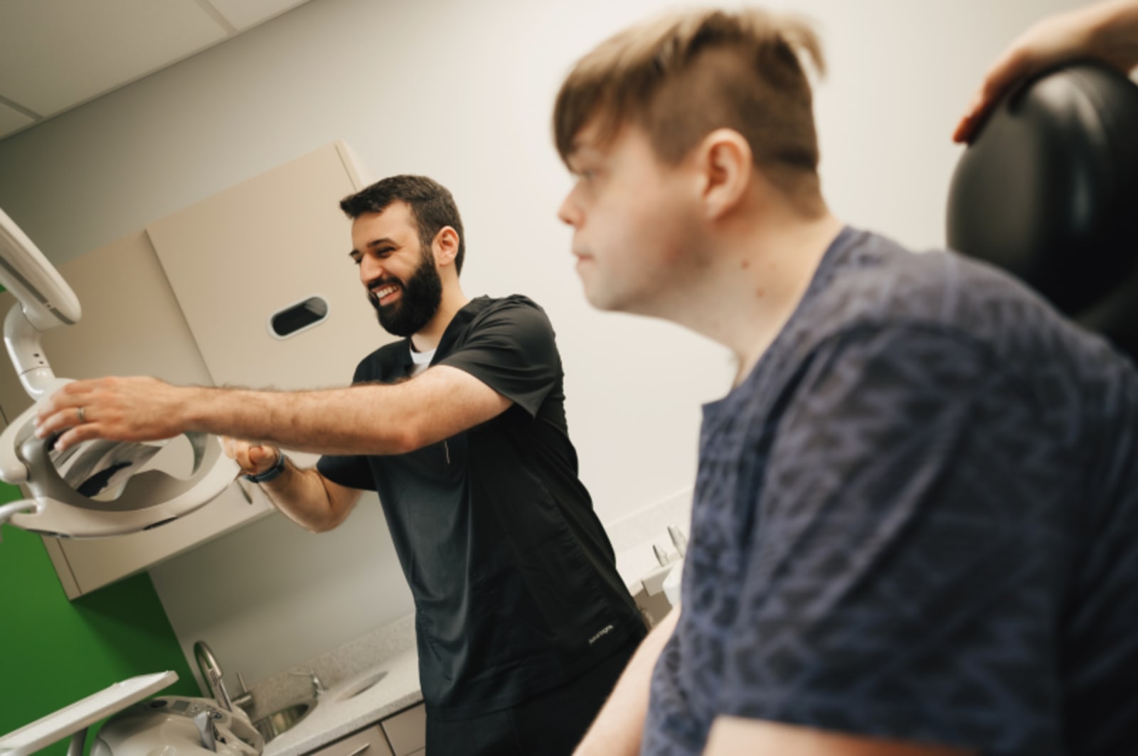 Dentist demonstrating or explaining dental equipment to a patient during a consultation