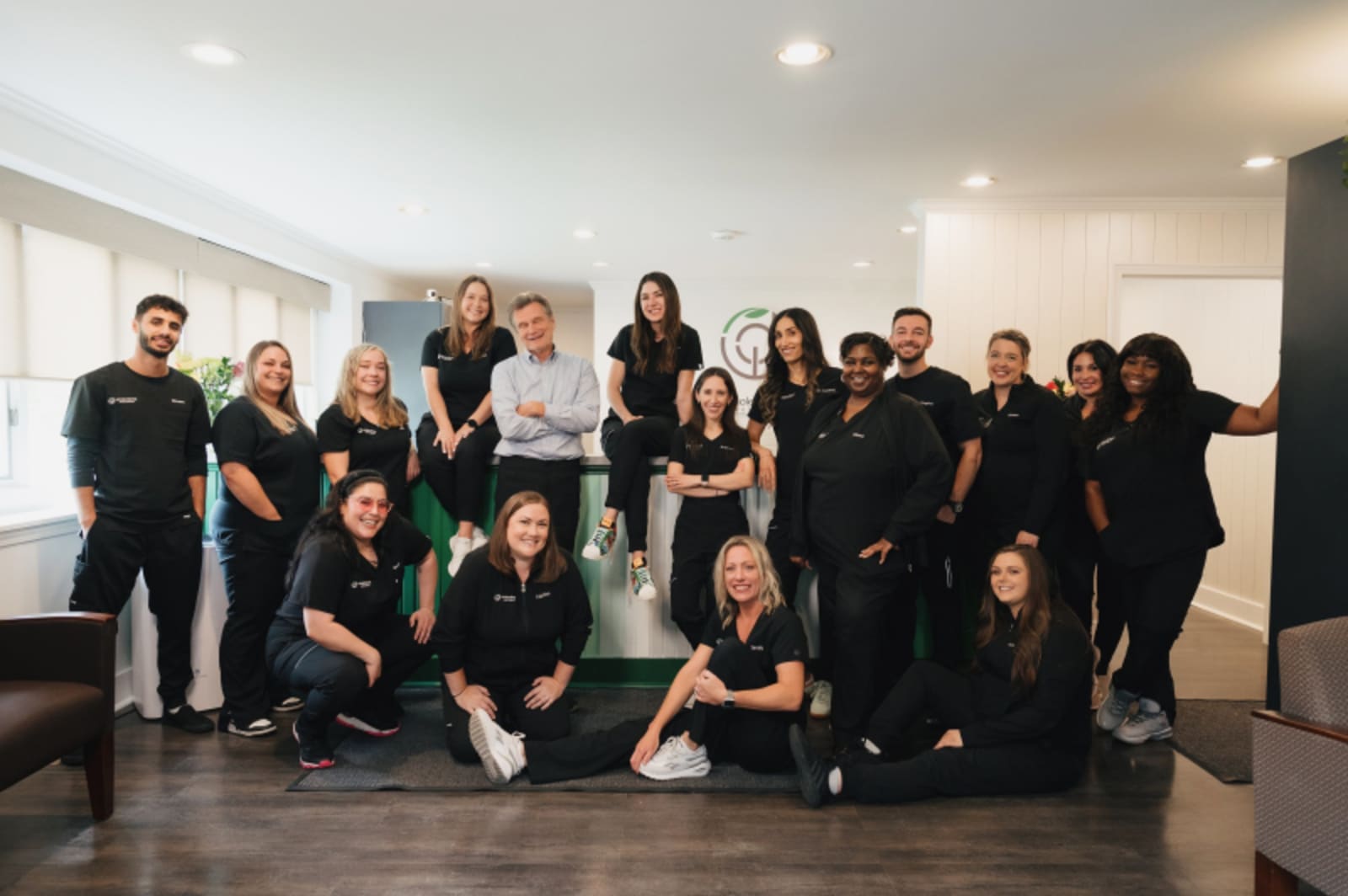 Team photo of diverse dental professionals smiling together indoors