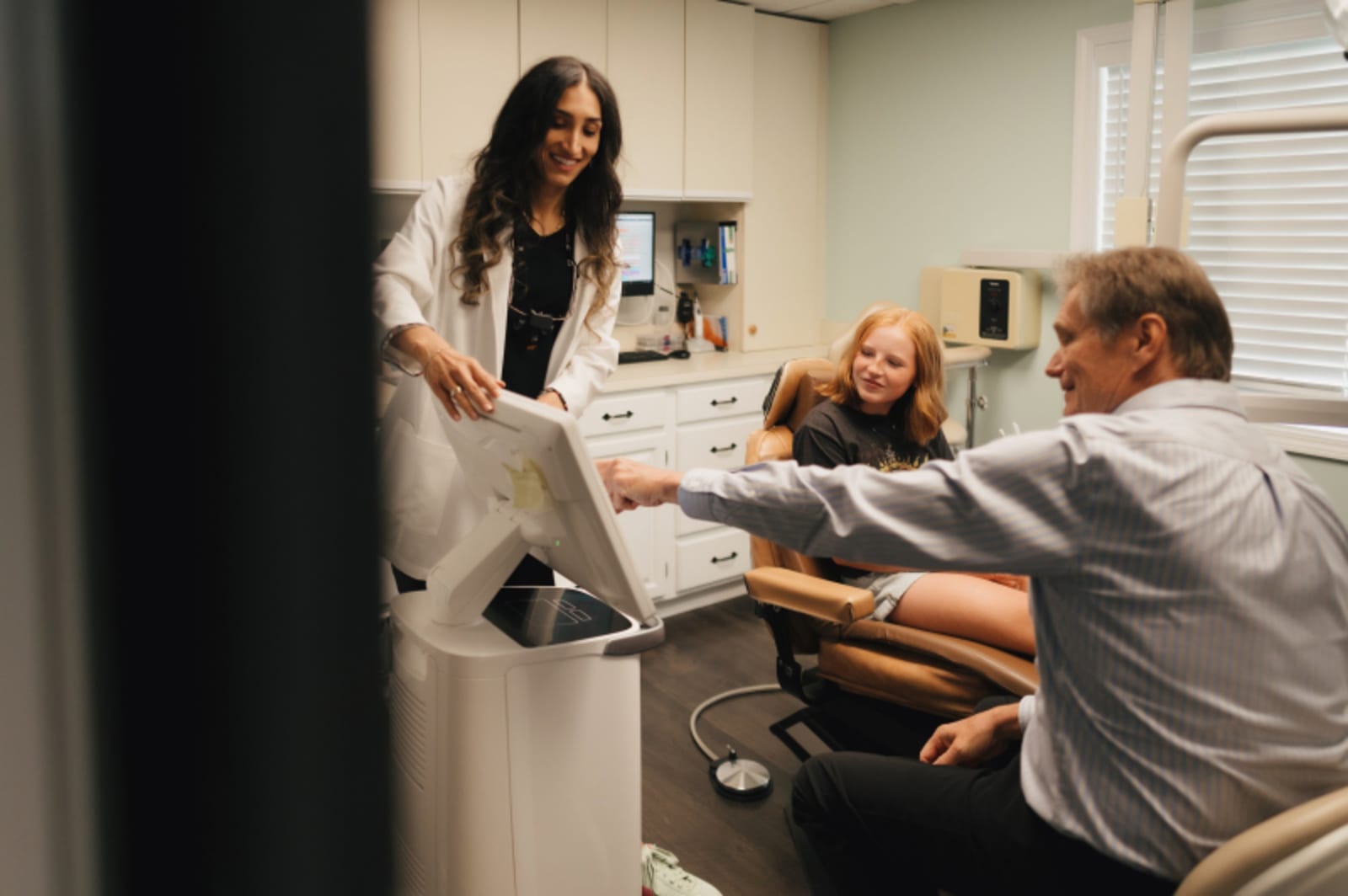 Dentist consulting with patient in treatment room during examination