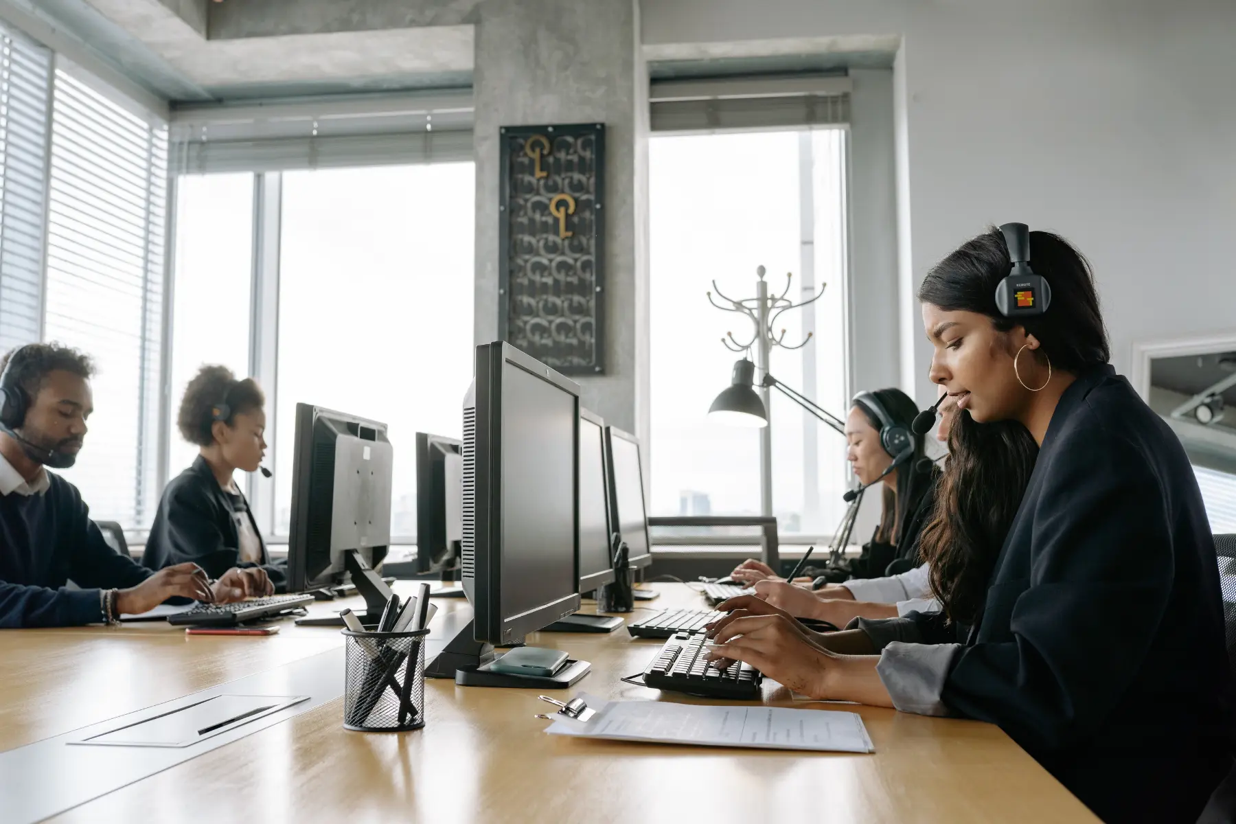 Agency staff on headsets working accounts at a row of desks