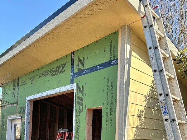 Exterior sheathing and wood siding around a doorway during construction