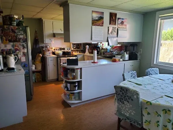 Kitchen and dining area with white cabinets, a peninsula, and wood flooring