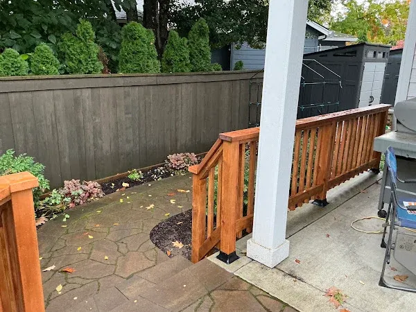 Wood patio railing and a handrail beside steps and a porch column