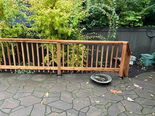 Wood railing along the edge of a stamped-concrete patio