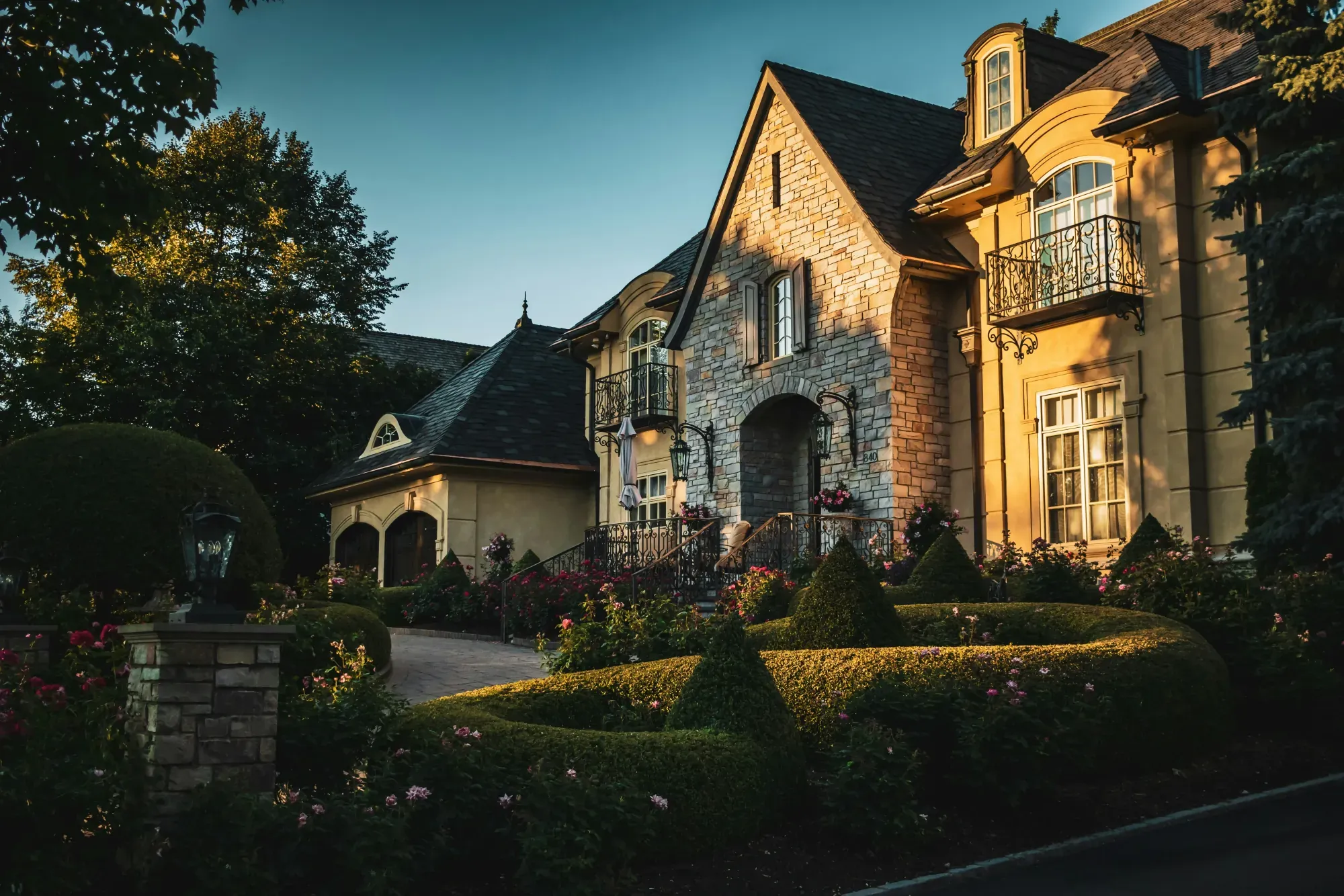 Stone house with an arched entrance and landscaped gardens