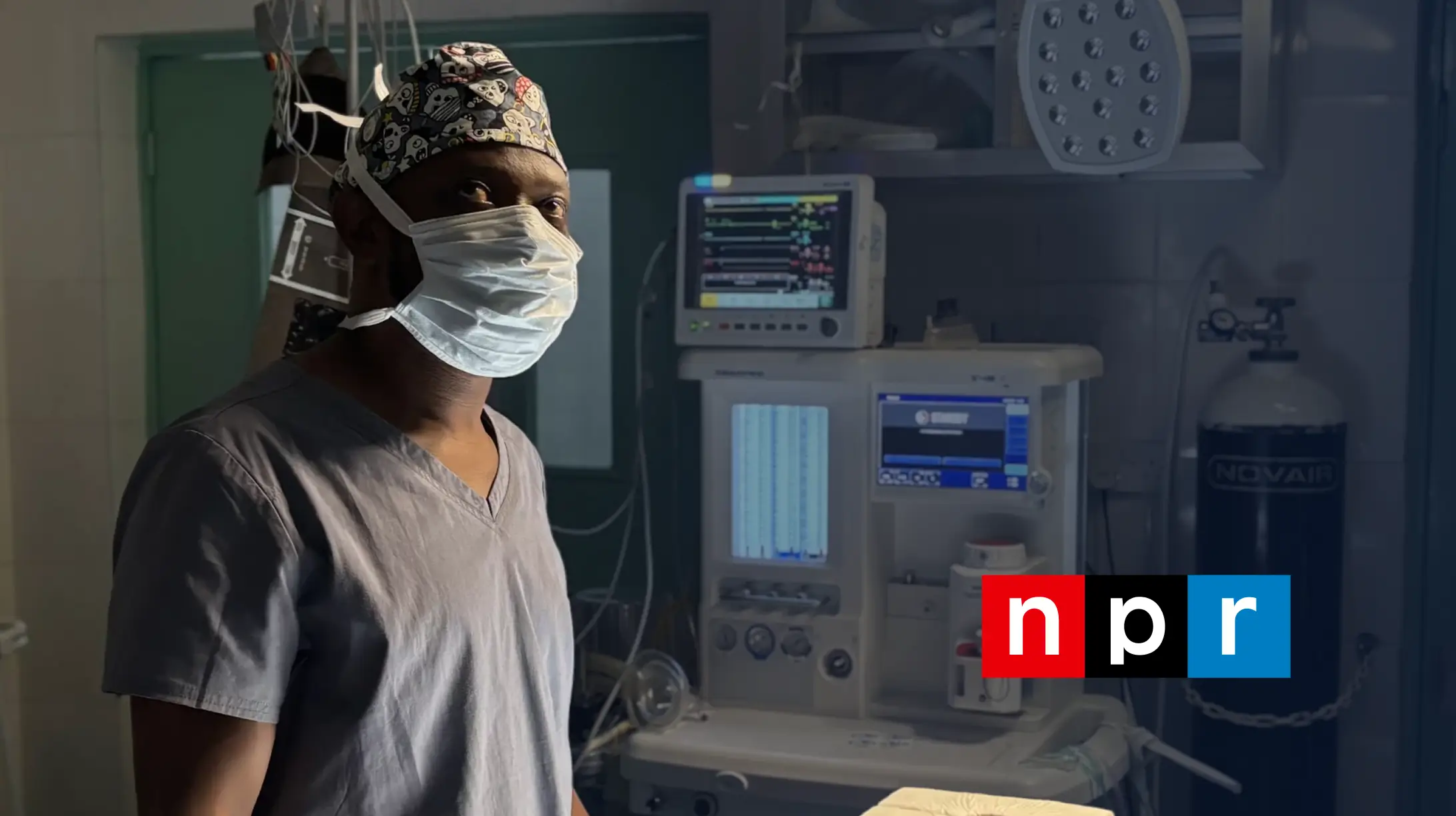 Dr. Alieu Kamara, Sierra Leone’s first neurosurgeon, standing in an operating room beside medical equipment. NPR feature image.