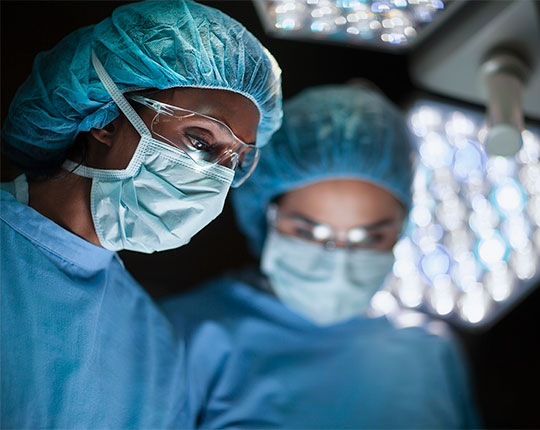 Two surgeons in an operating room wearing masks