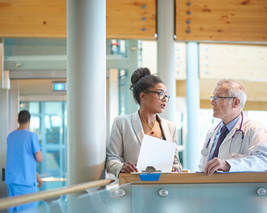 Two physicians talking to each other in a medical building