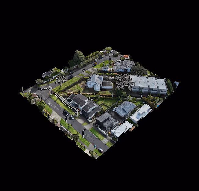 Aerial view of suburban houses with yards, trees, roads, and sidewalks.