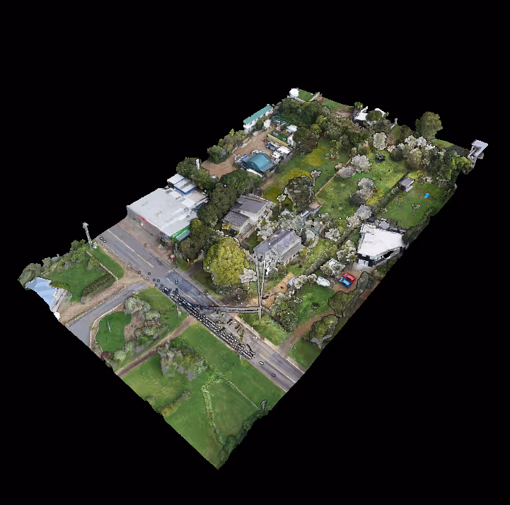 Aerial view of a rural property featuring multiple buildings, trees, green lawns, and a road crossing the lower part of the image.