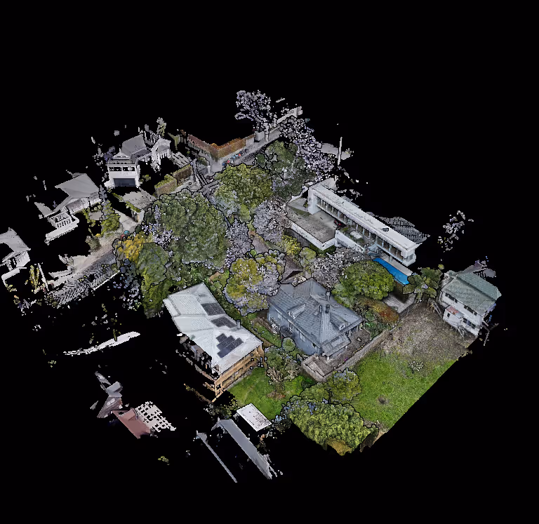 Aerial view of a residential area showing several houses surrounded by trees and greenery.