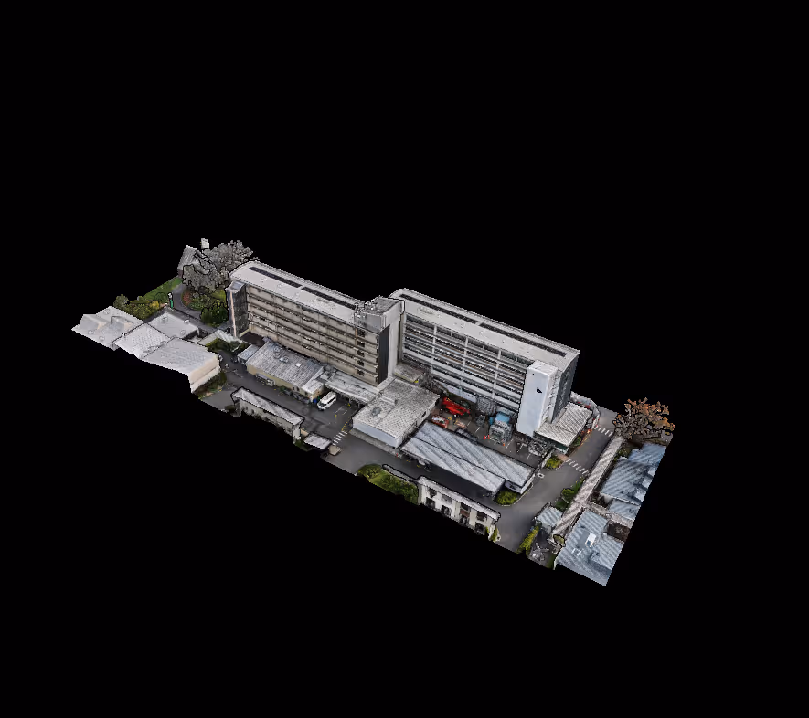 Aerial view of a multi-storey hospital complex with adjacent parking and greenery.
