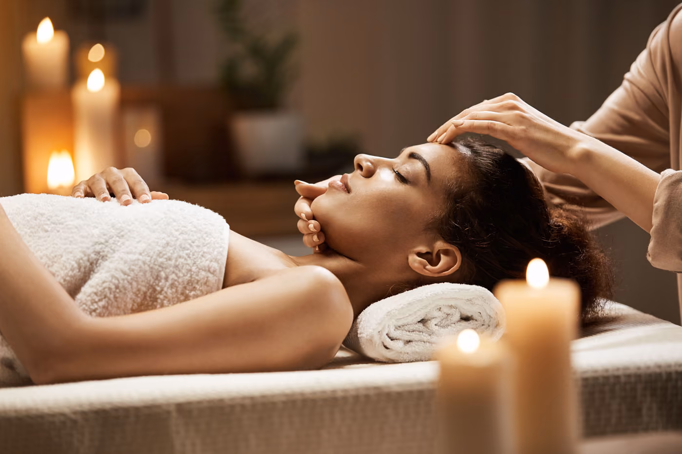 Attractive African Woman Enjoying Face Massage at a spa/salon.