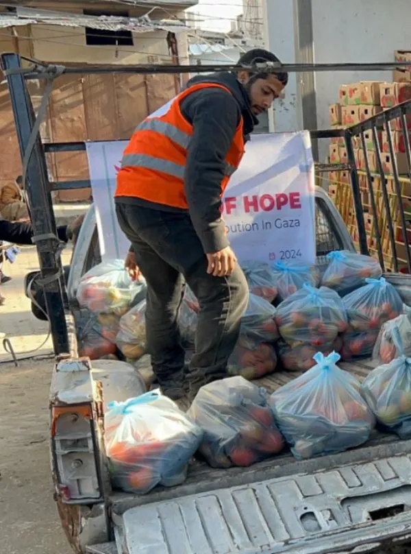 Umma Relief volunteer loading a truck with fresh fruit and vegetable baskets for distribution to underserved communities.