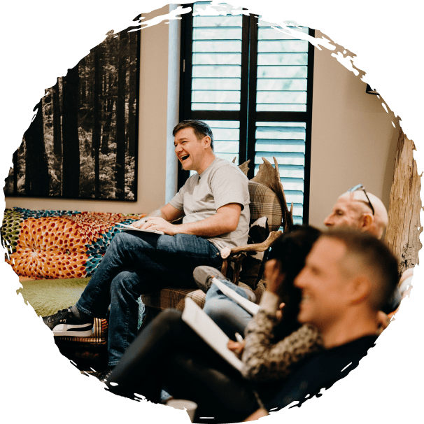 Retreat member sitting in a chair in a living room. Enjoying the discussion with other members.
