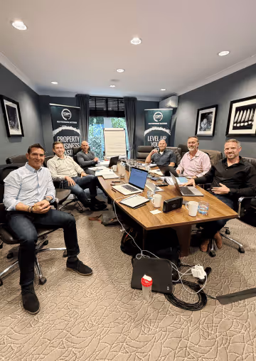 Mastermind delegates sitting round a board table.