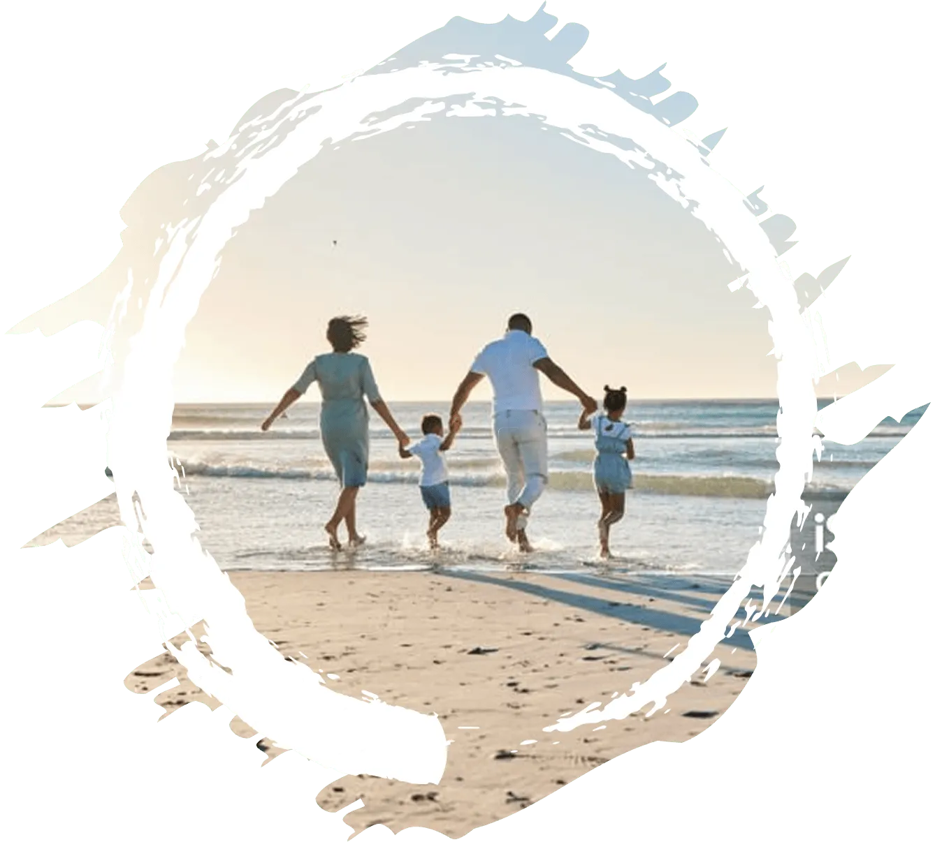 A family walking on the beach holding hands.